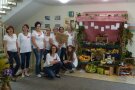 Mehrere Frauen neben Stand mit Obstkisten und -schalen