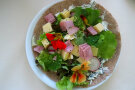 bunte Salatblätter, Radieserl mit Schinken- und Käsestückchen auf Wrap-Brot