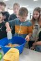 Junge rührt mit Mixer Teig in einer blauen Rührschüssel